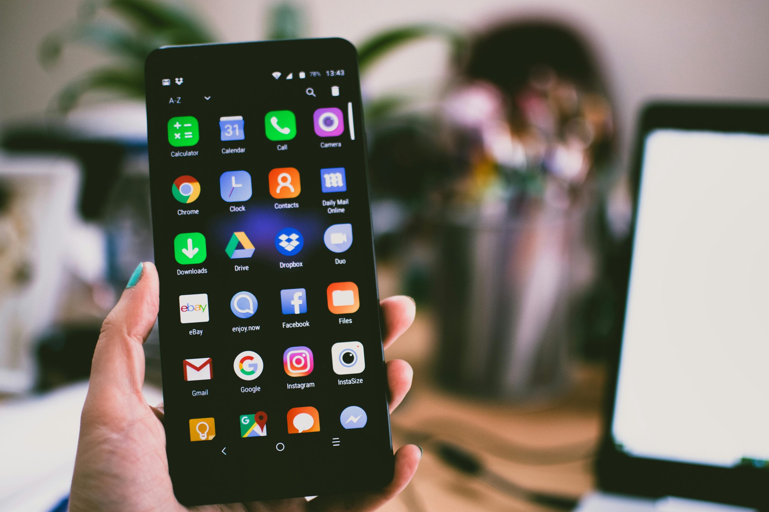 pexels-photo-1092644-1092644 A close-up image of a person's hand holding a smartphone displaying various popular apps.