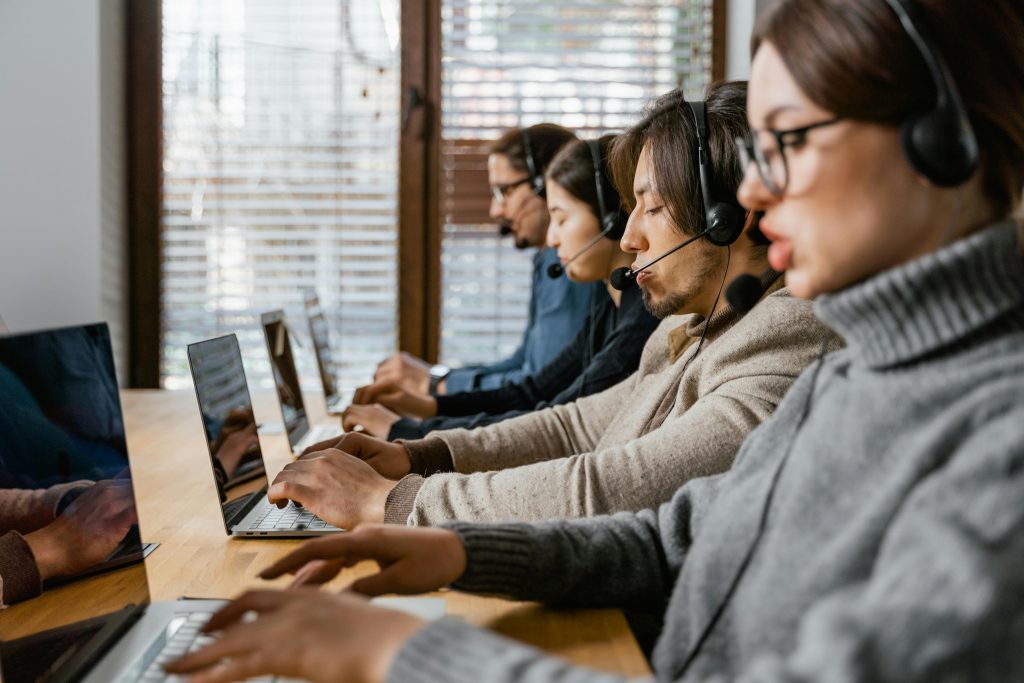 A group of professionals collaborating in an office setting, engaging in customer support.